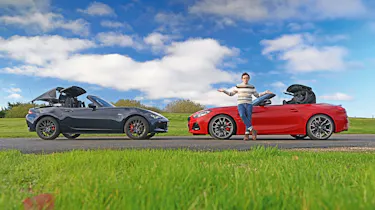 Auto Express consumer reporter Tom Jervis standing in front of a Mazda MX-5 and BMW Z4