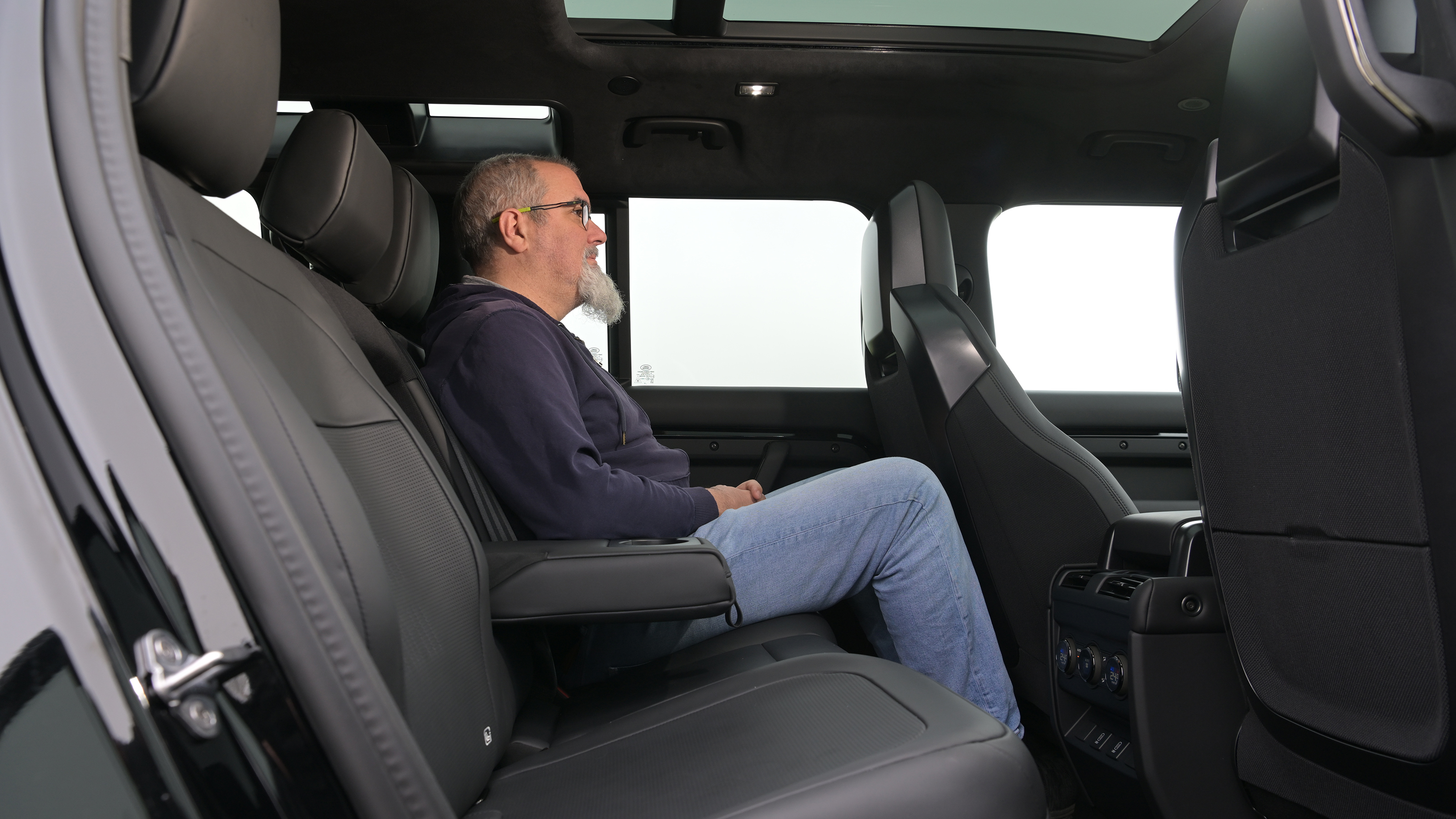 Auto Express senior test editor Dean Gibson sitting in the Land Rover Defender OCTA Black's rear seat