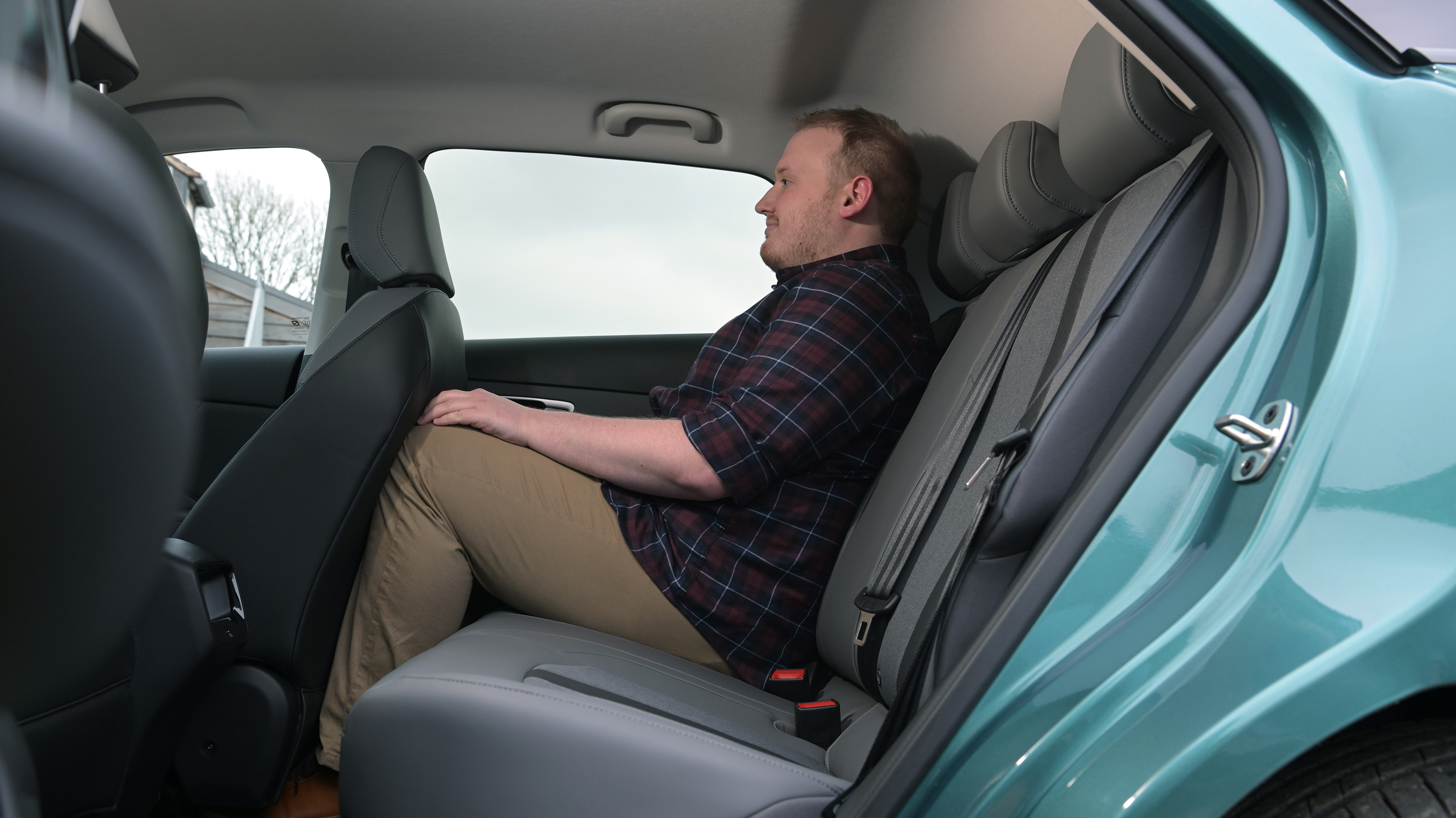 MG4 facelift - rear seats being sat in by Auto Express news reporter Ellis Hyde 