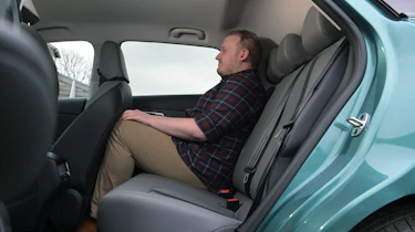 MG4 facelift - rear seats being sat in by Auto Express news reporter Ellis Hyde