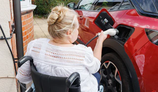 Person in wheelchair plugging in car Alistair Veryard photography