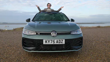 Auto Express consumer editor Tom Jervis standing through a Volkswagen Passat's sunroof