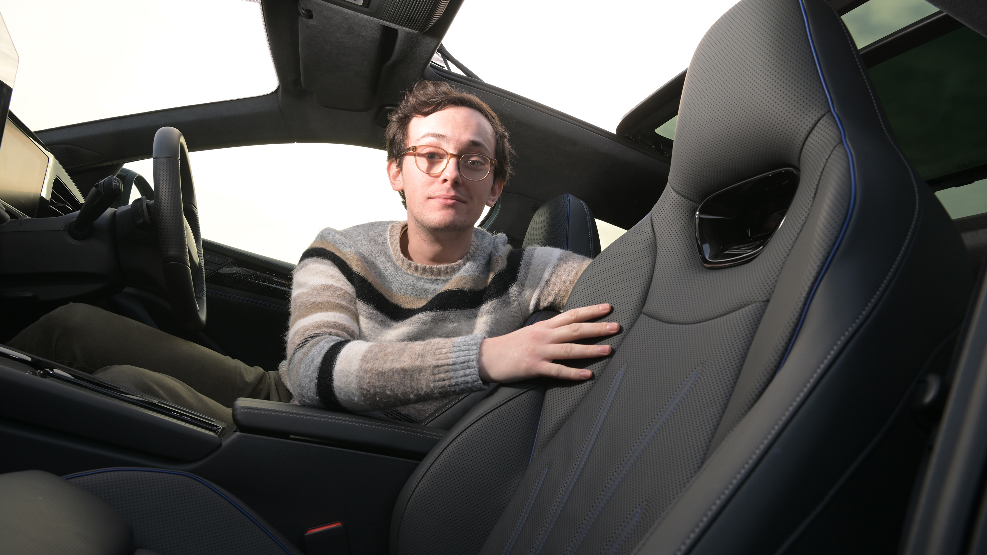 Auto Express consumer editor Tom Jervis touching a Volkswagen Passat's seat