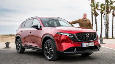 Auto Express news reporter Ellis Hyde standing next to a Mazda CX-5