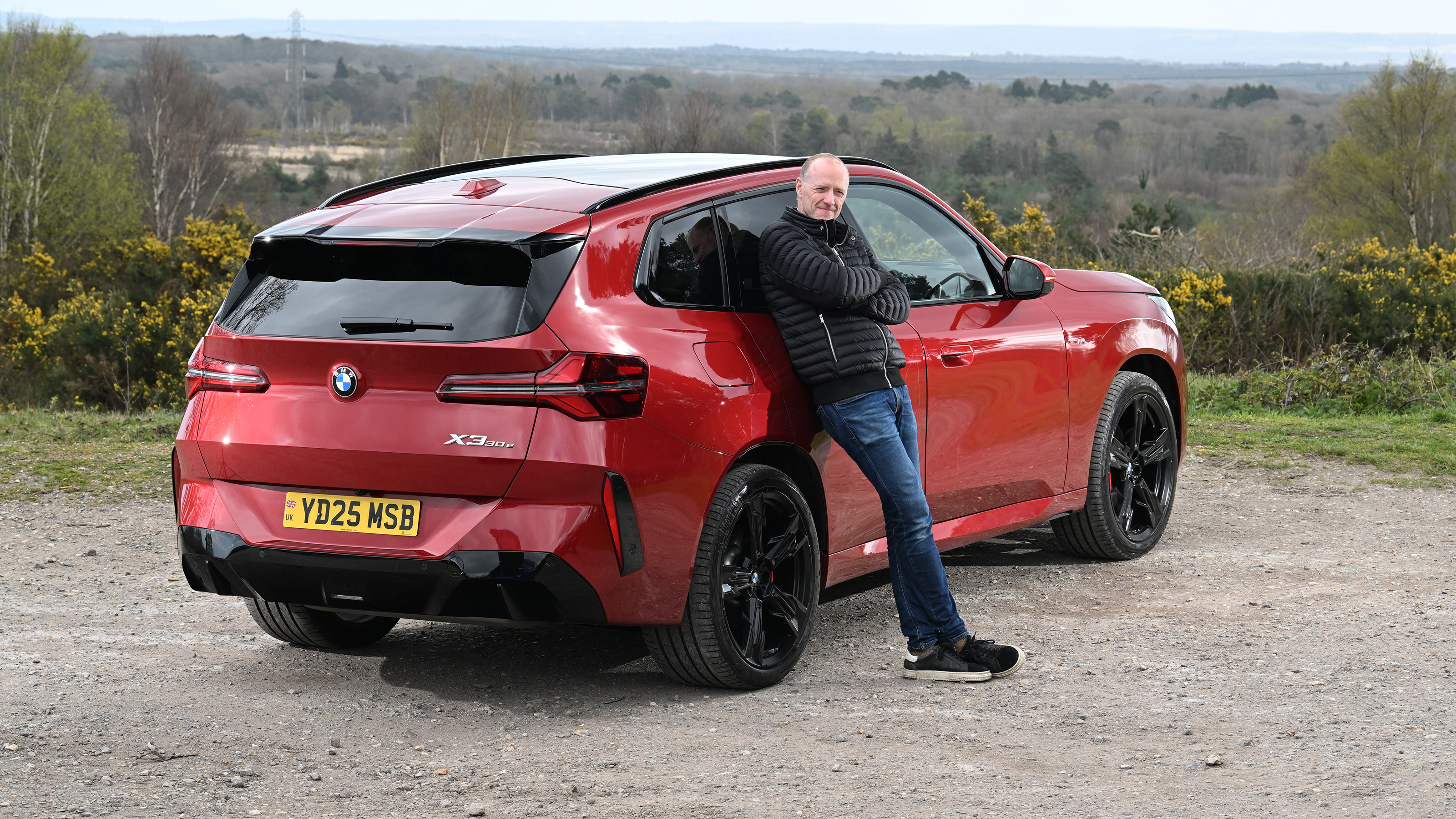 Auto Express Phil McNamara leaning against the BMW X3 30e xDrive M Sport
