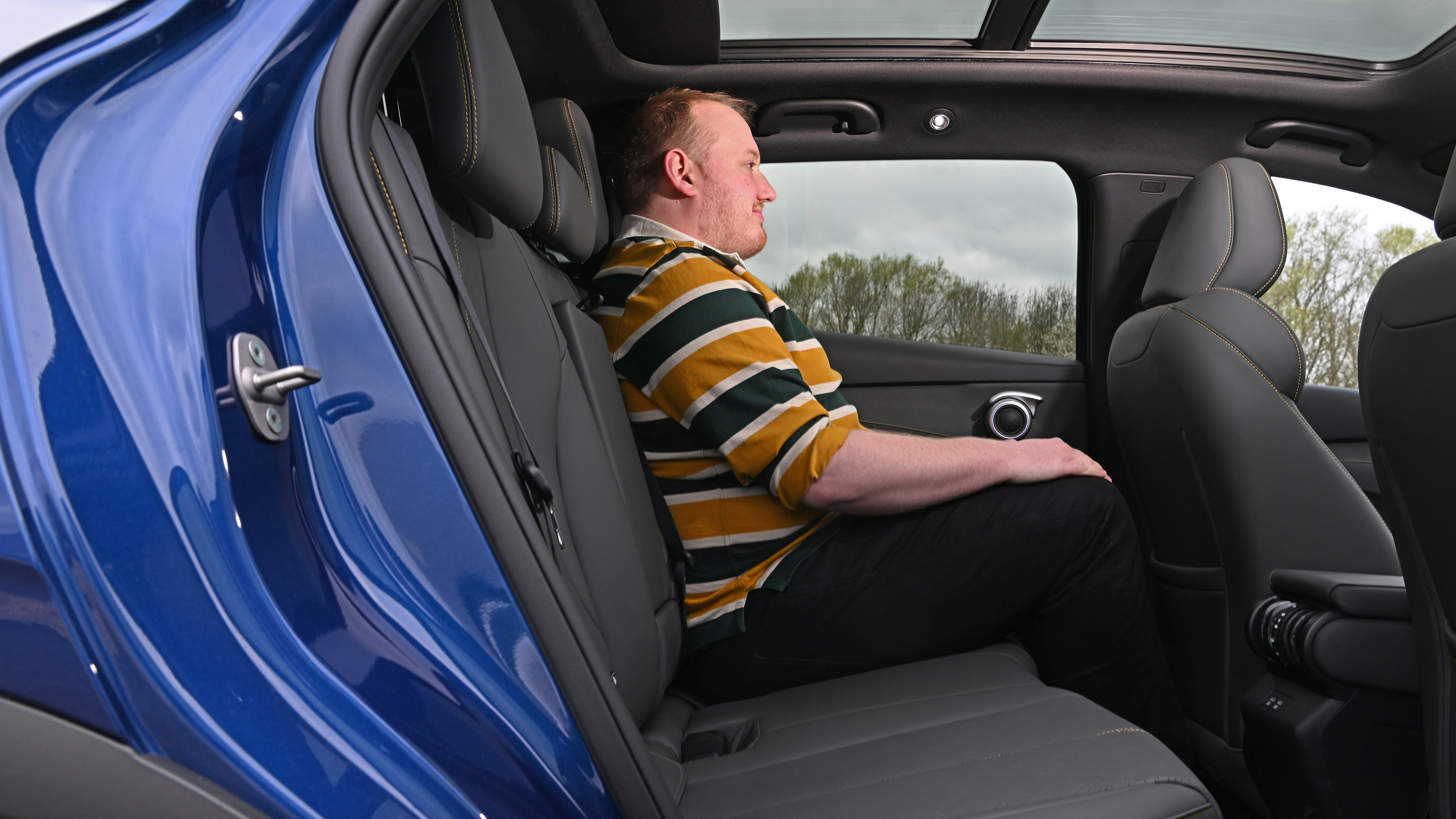 Auto Express news reporter Ellis Hyde sitting in the BYD Atto 3 EVO's rear seat
