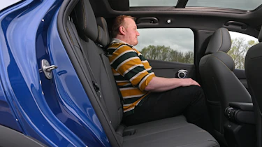 Auto Express news reporter Ellis Hyde sitting in the BYD Atto 3 EVO's rear seat