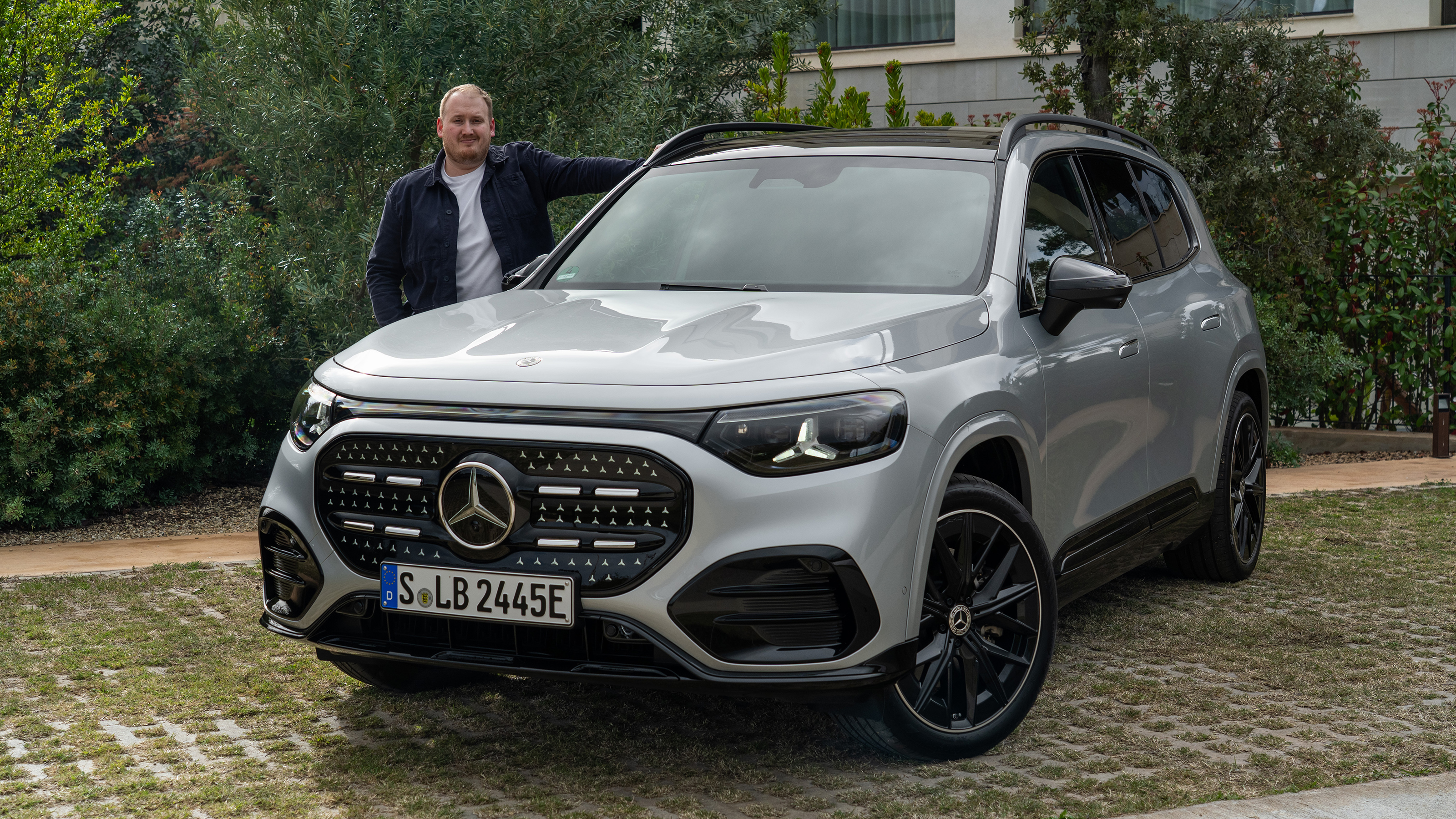 Auto Express news reporter Ellis Hyde standing next to the Mercedes GLB Electric