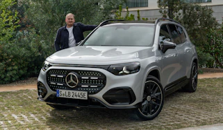 Auto Express news reporter Ellis Hyde standing next to the Mercedes GLB Electric