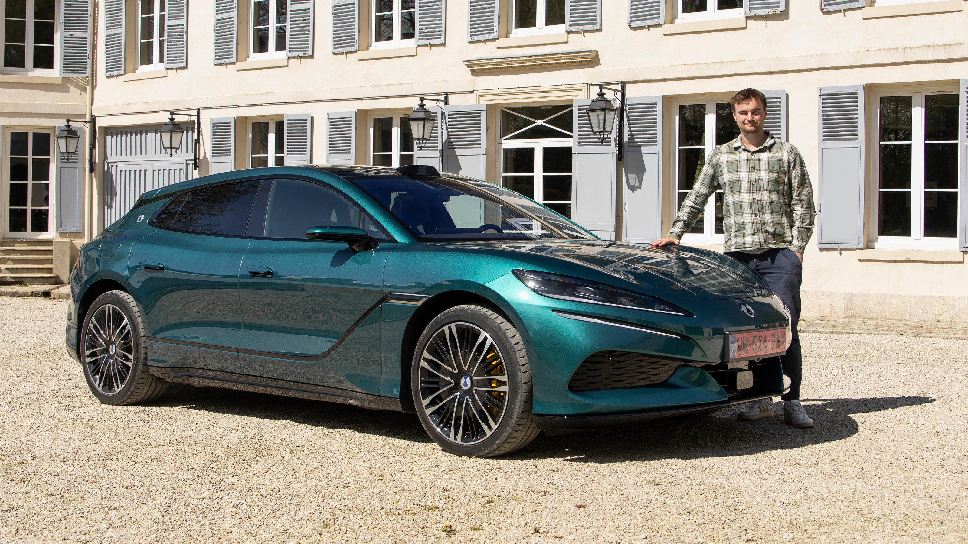 Auto Express senior news reporter Alastair Crooks standing next to the Denza Z9GT EV