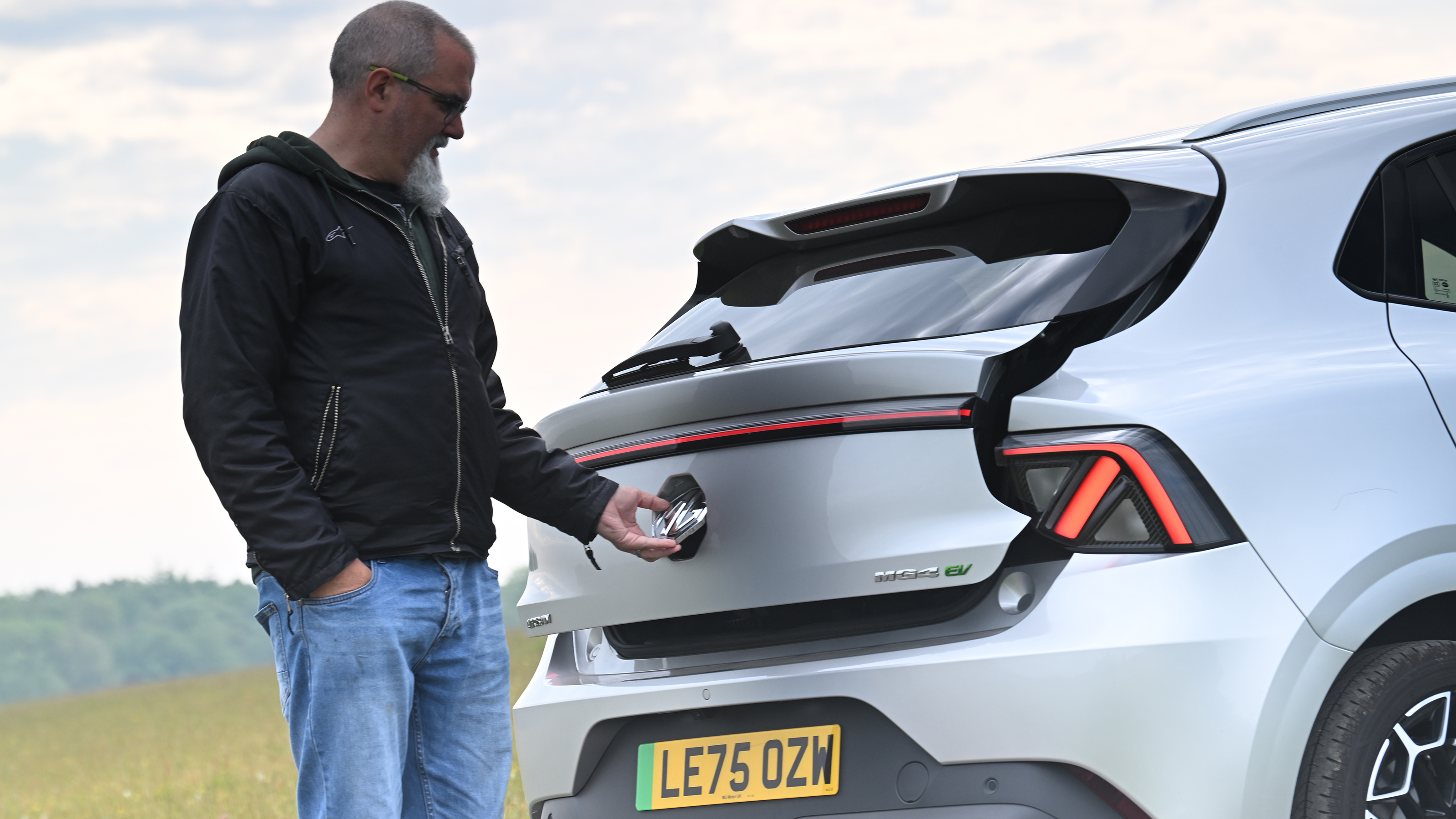 Auto Express senior test editor Dean Gibson opening the MG4 Urban's tailgate