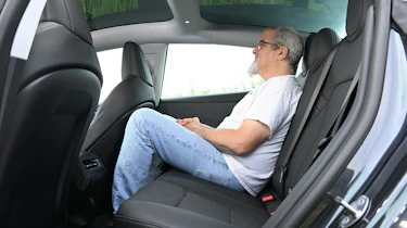 Auto Express senior test editor Dean Gibson sitting in the Tesla Model 3's rear seat