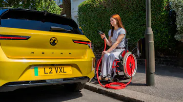 Wheelchair user charging a Vauxhall Astra Electric
