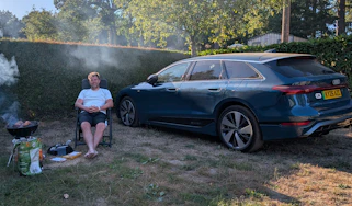Auto Express head of digital content Steve Walker sitting between the Audi A6 Avant e-tron and a barbecue