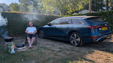 Auto Express head of digital content Steve Walker sitting between the Audi A6 Avant e-tron and a barbecue