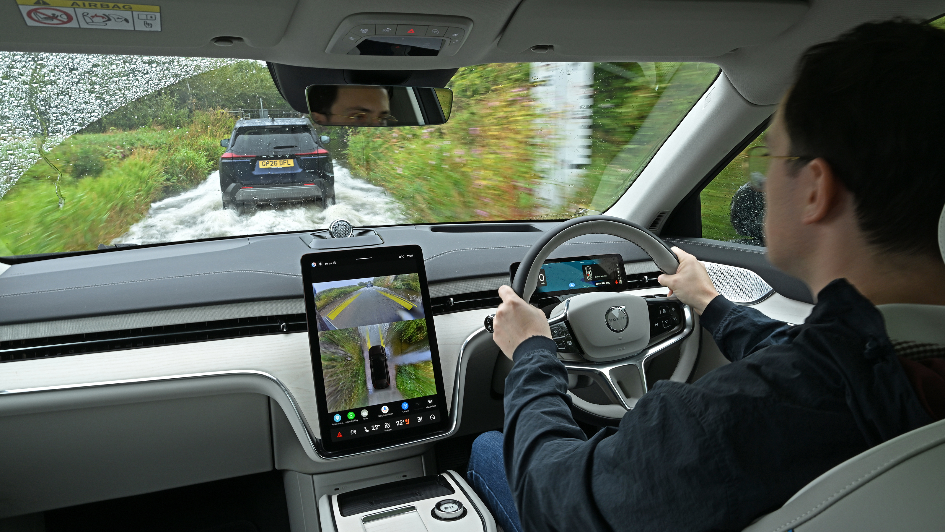 Auto Express consumer reporter Tom Jervis driving a Volvo EX90 through deep water