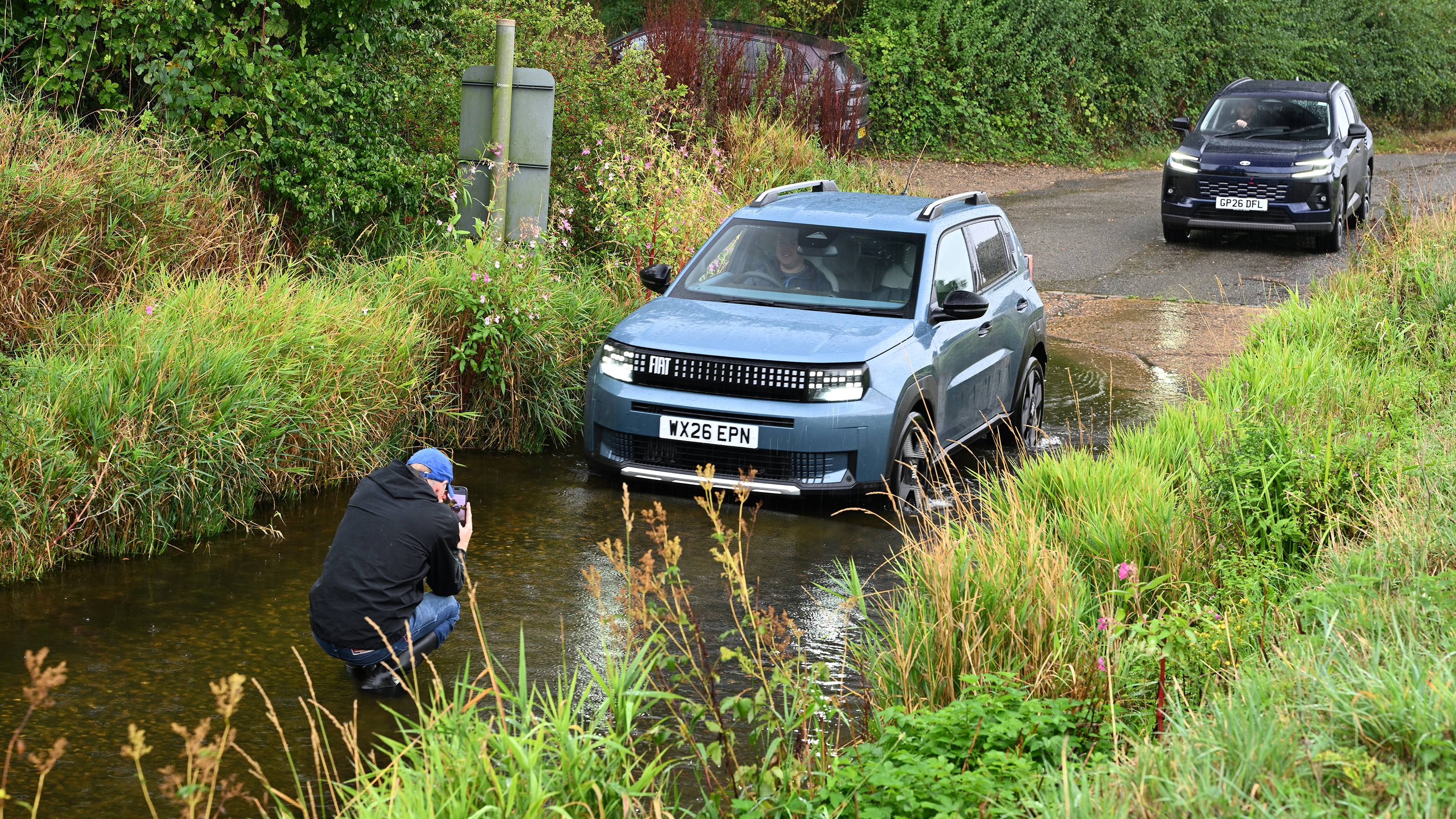Auto Express creative director Darren Wilson taking pictures of a Fiat Grande Panda in ford water