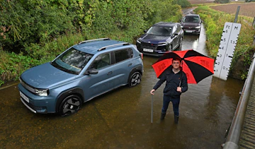 Auto Express consumer reporter Tom Jervis standing next to a selection of cars in a ford