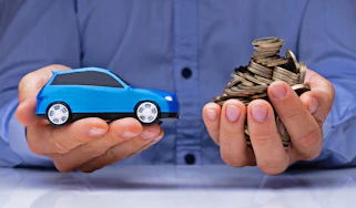 Hands holding a toy car and coins